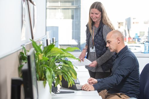 Two Corrections staff talking at a computer